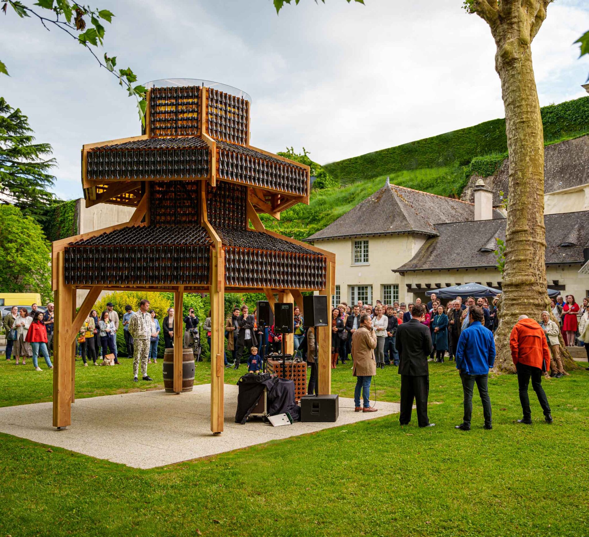 Oeuvre ressemblant à une pagode orientale dans le parc de la Maison Ackerman avec des gens réunis autour.